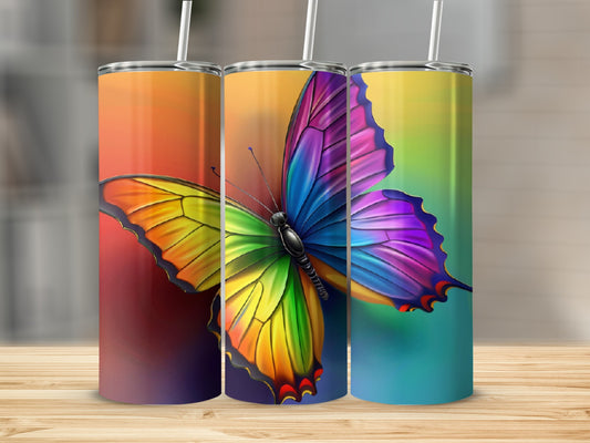 Rainbow butterfly tumbler with colorful gradient background.