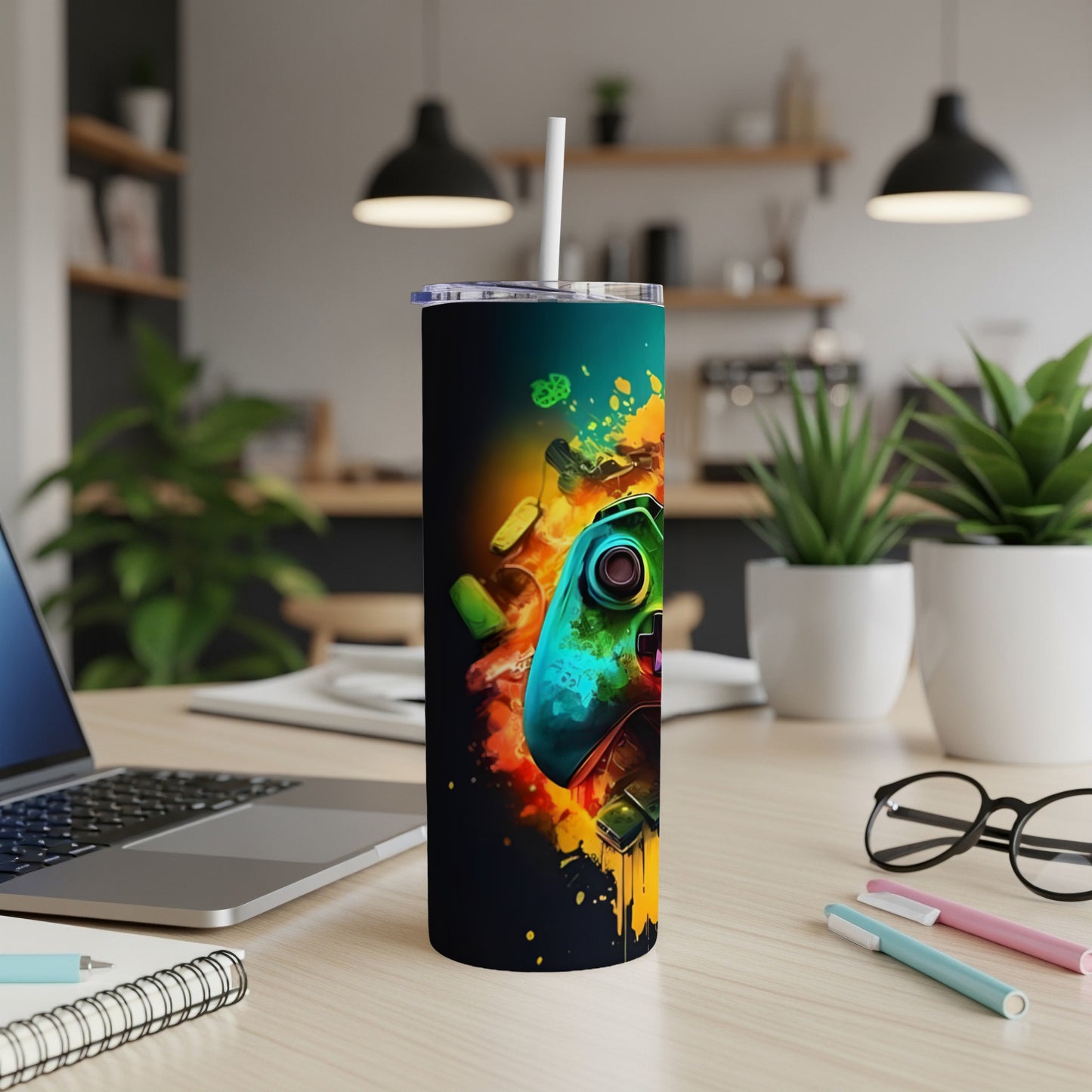 Gaming controller on a dark tumbler with colorful abstract paint splatter.