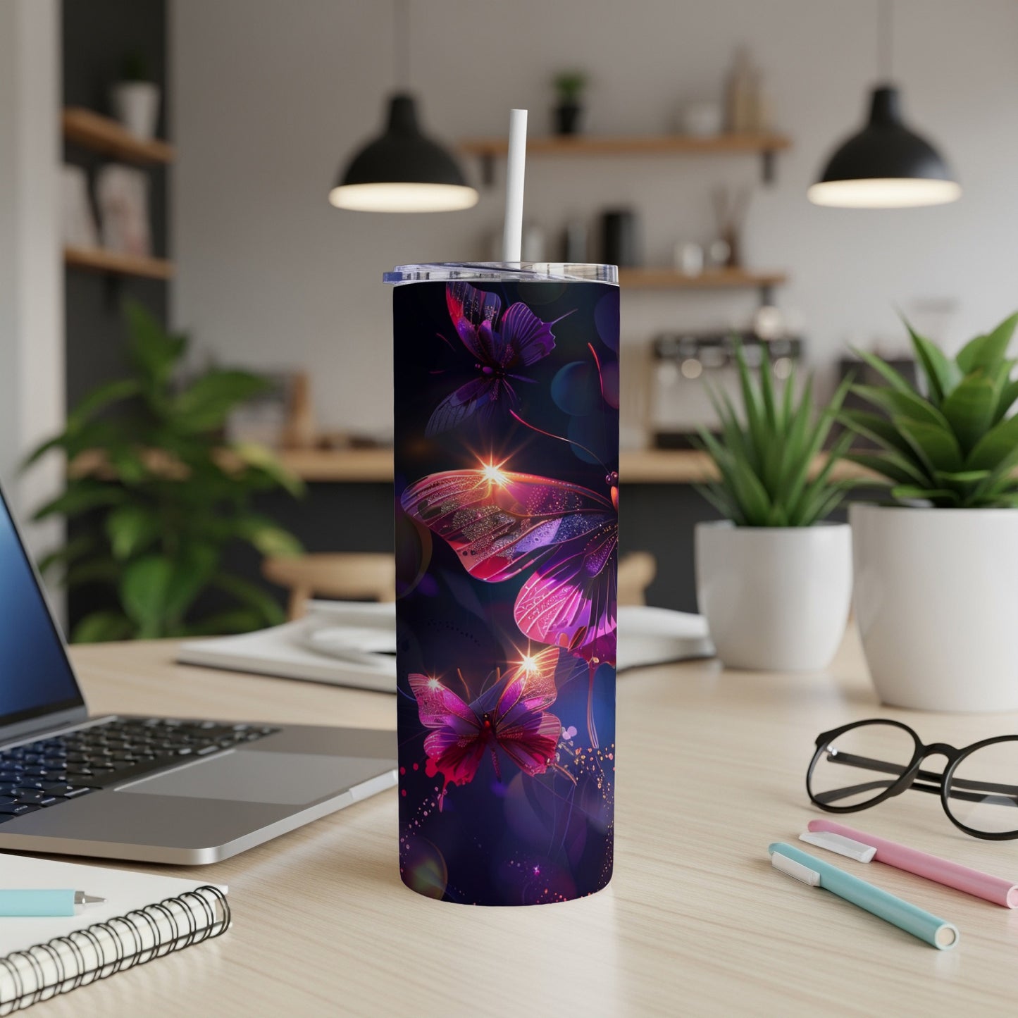 Purple and pink butterfly tumbler with straw on a desk.