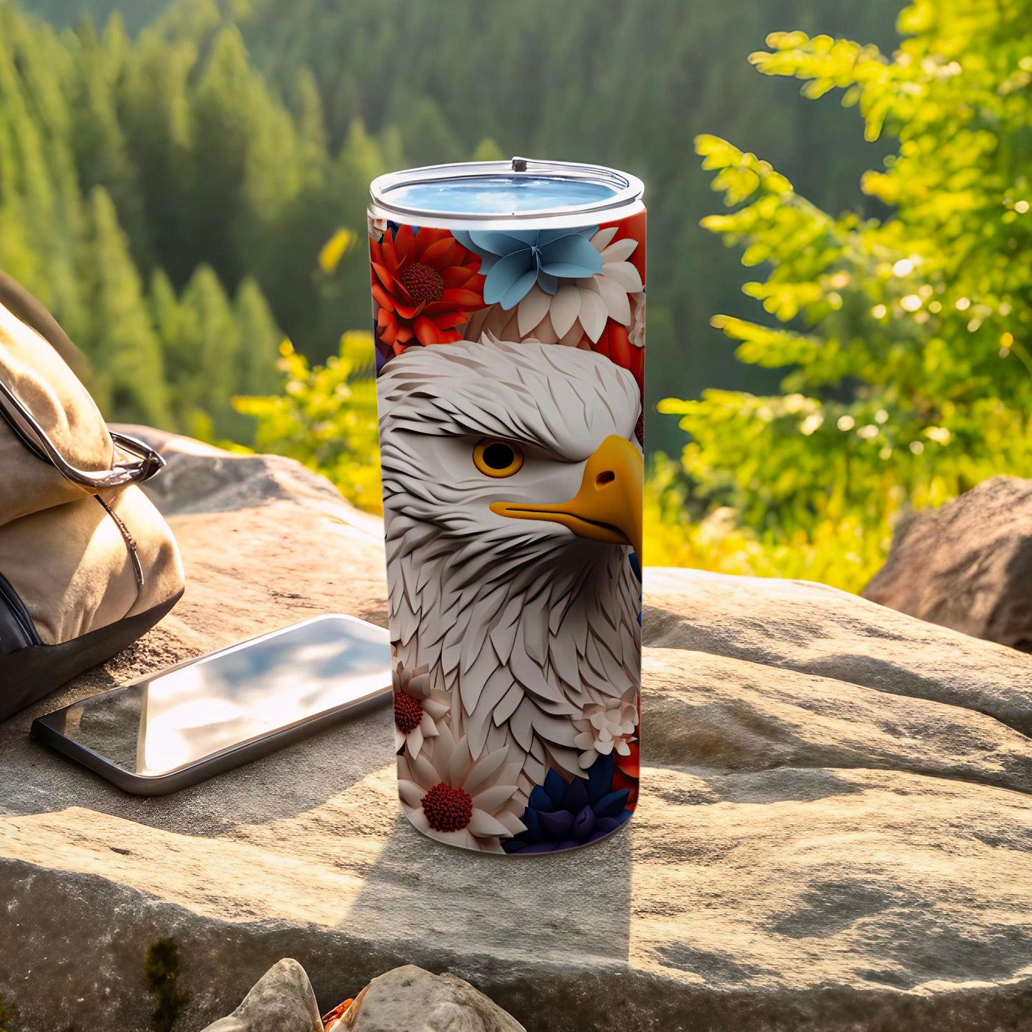 Tall tumbler with eagle and floral design on a rock.