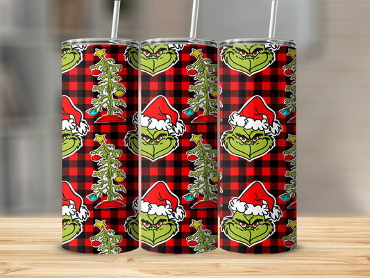 Grinch wearing Santa hat with Christmas tree on buffalo plaid background.
