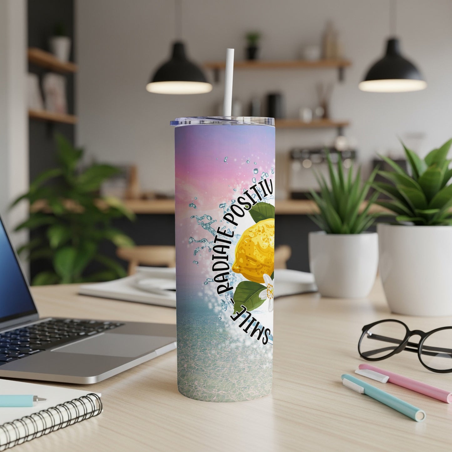 Stainless steel tumbler with lemon and "Radiate Positivity Smile" text on a desk.