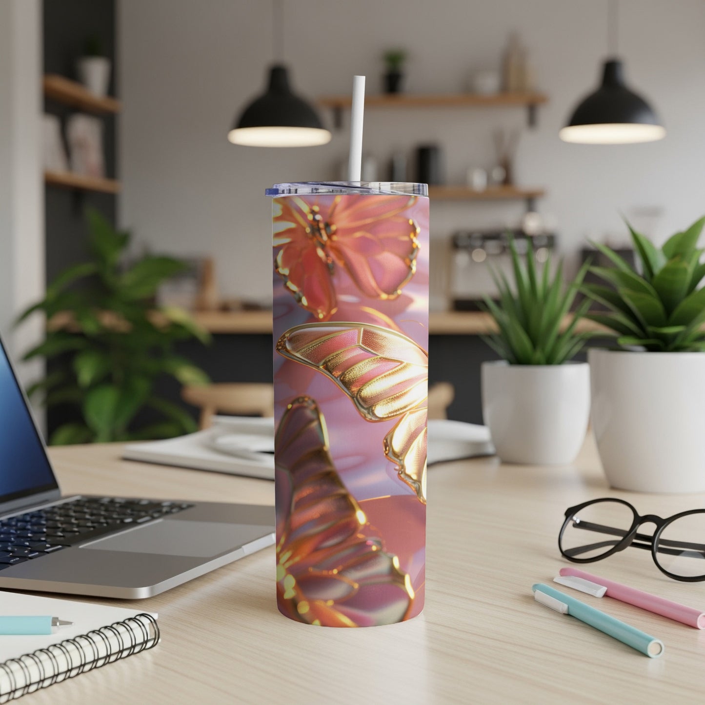 Pink and gold metallic butterflies wrap around a skinny tumbler with a straw.