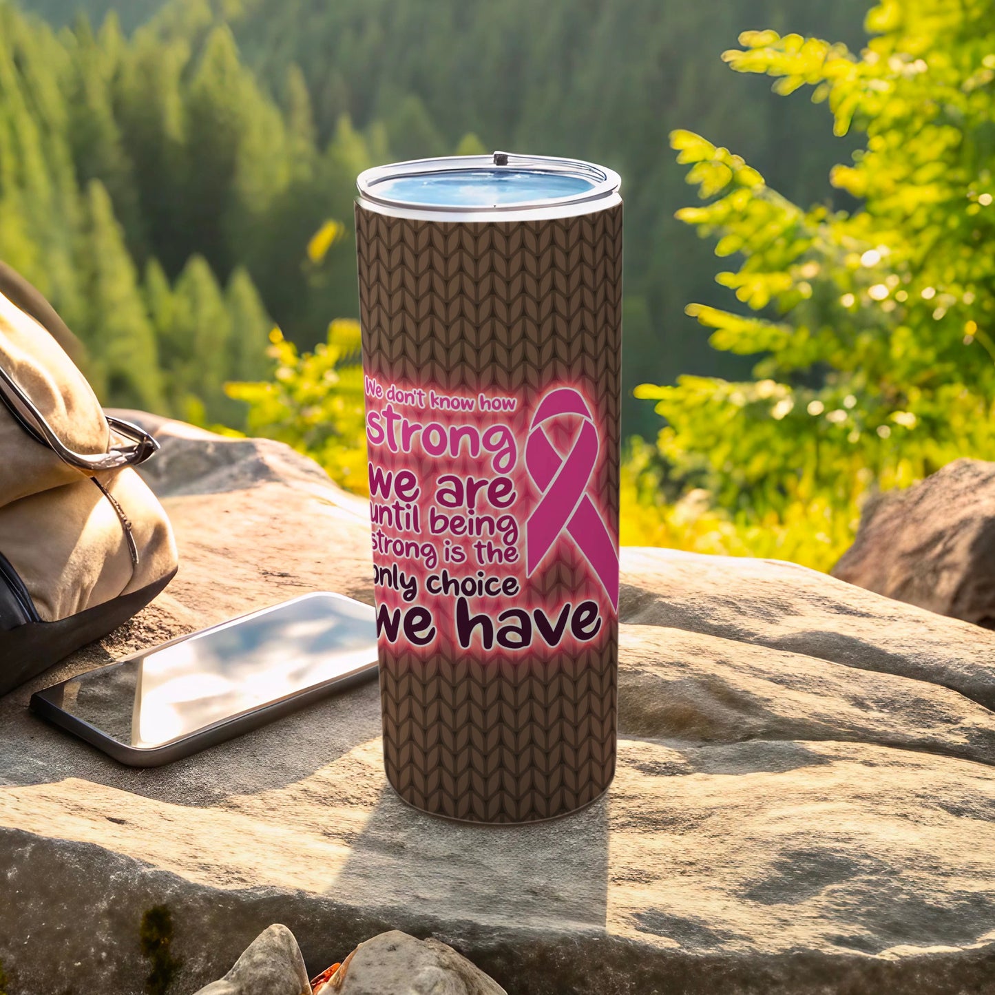 Pink ribbon tumbler with inspirational quote about strength on a textured background.