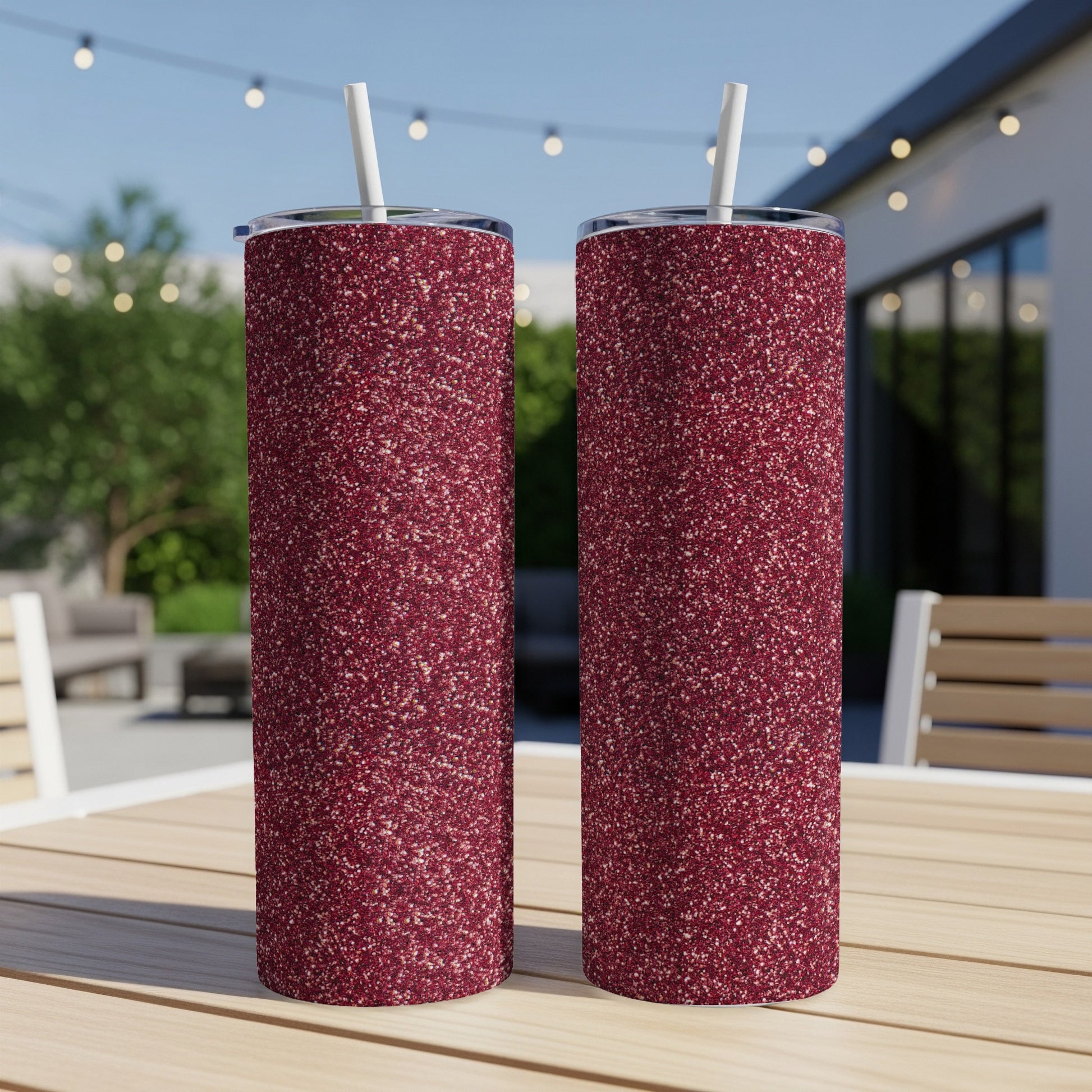 Two tumblers with a textured dark red glitter finish and white straws.