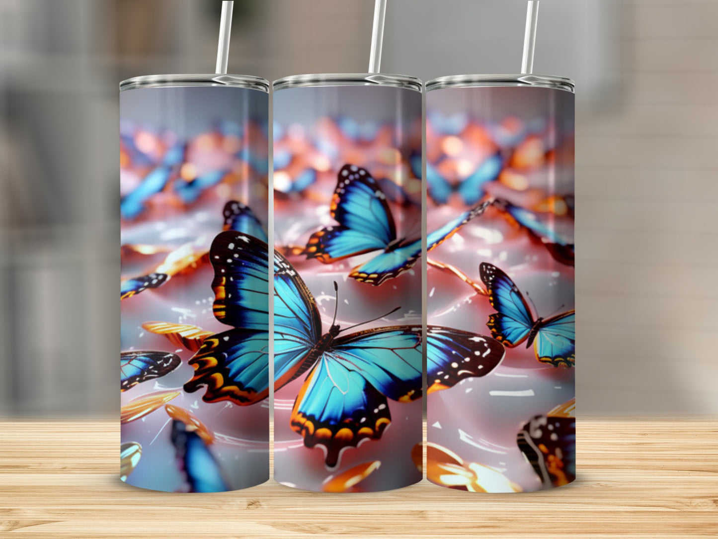 Three tumblers with blue butterflies against a blurred background.