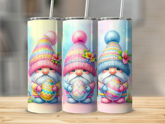 Three gnomes in colorful hats hold Easter eggs on a wooden surface.