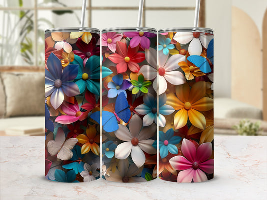 Three colorful floral tumblers with butterfly accents on a marble surface.