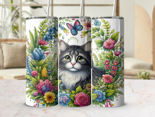 Gray tabby cat surrounded by colorful flowers and butterflies on a tumbler.