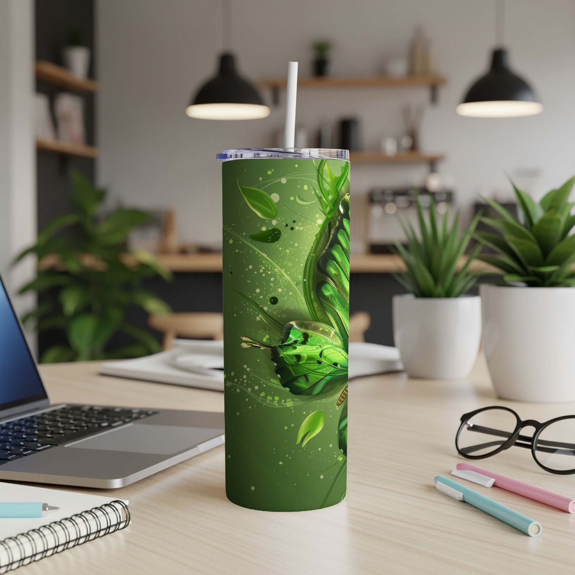 Green butterfly tumbler with straw on a desk.