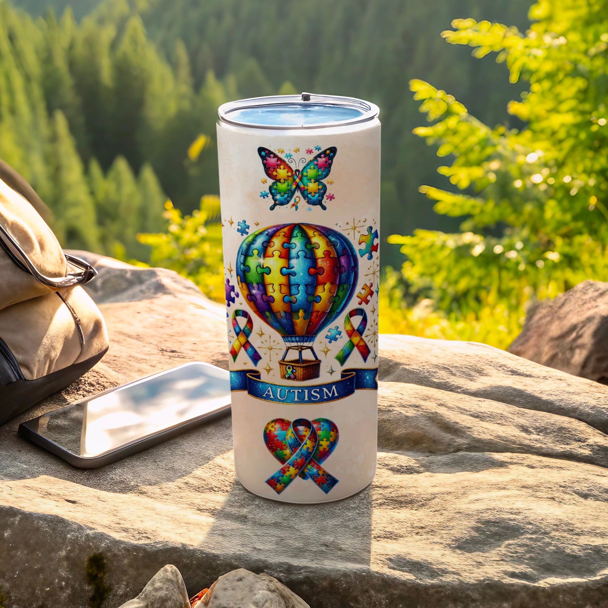 White tumbler with autism puzzle piece designs and butterflies.