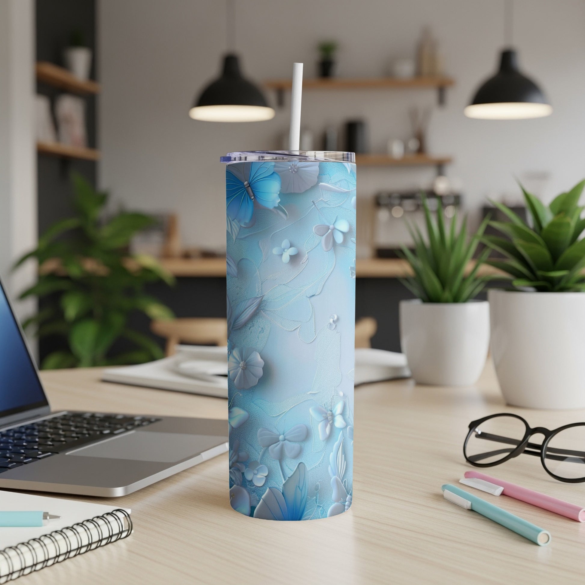 Blue floral and butterfly patterned tumbler with a white straw.