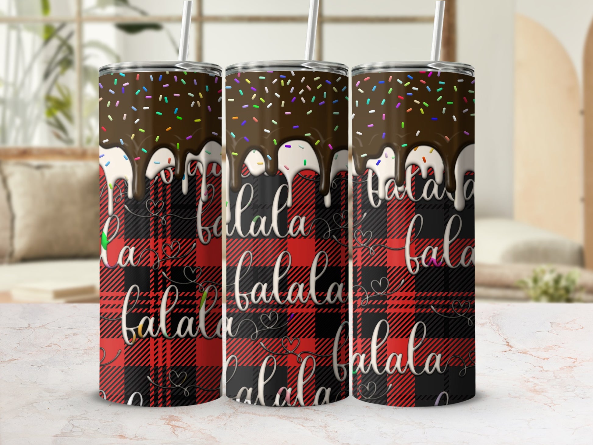 Three tumblers with chocolate drizzle, sprinkles, and "falala" text on plaid.