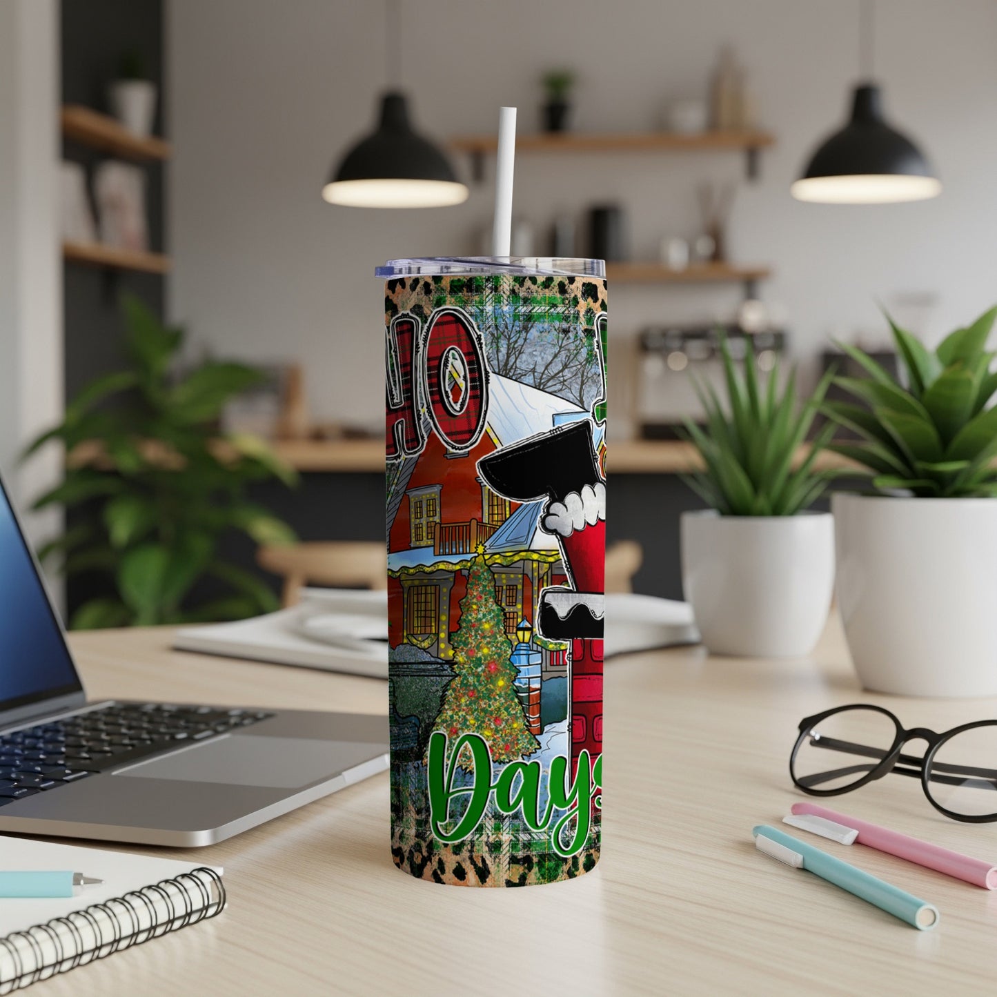 Christmas tumbler with Santa, tree, and "40 Days" text on a desk.