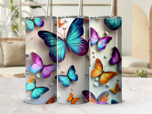 Three tumblers decorated with colorful butterflies on a speckled background.