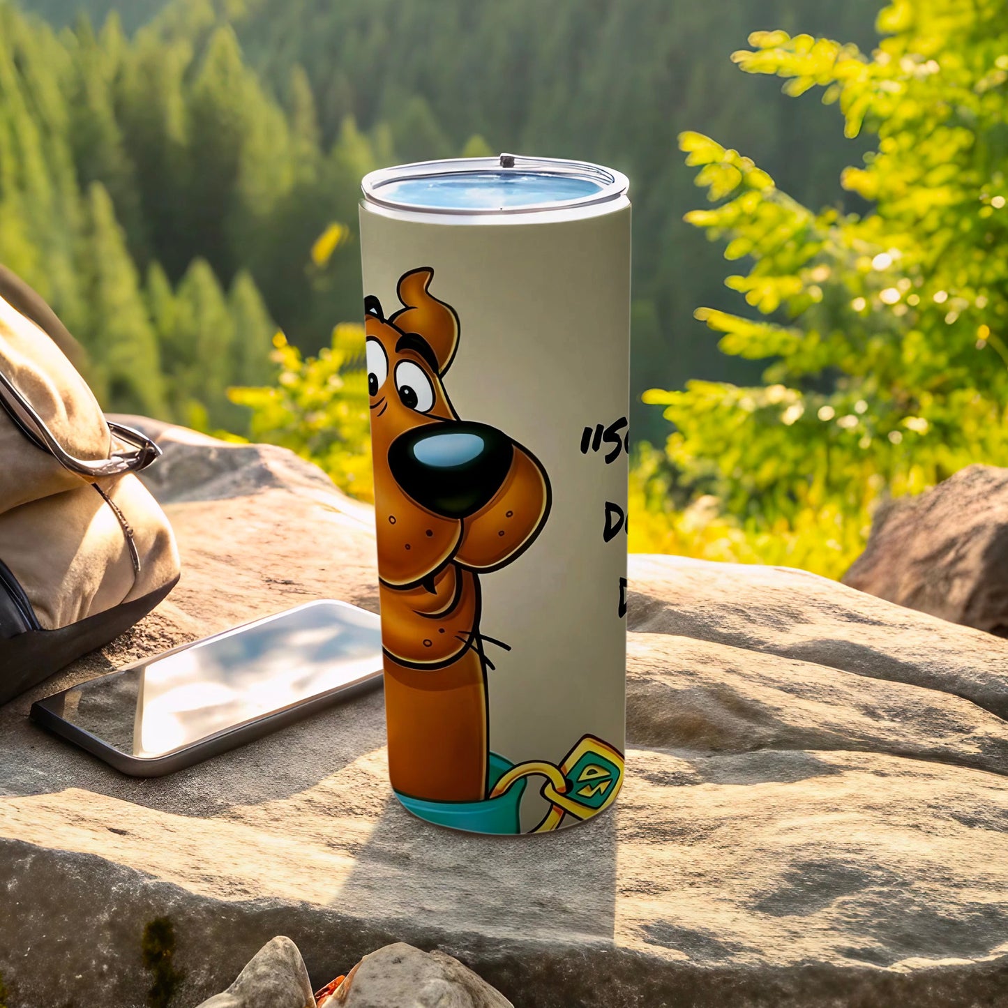 Scooby-Doo tumbler with text "It's so" and backpack outdoors.