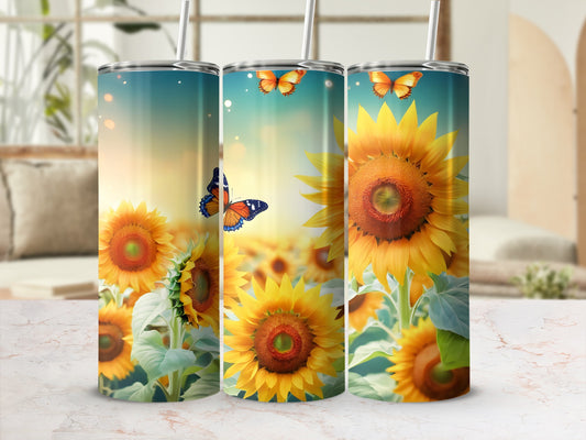 Three tumblers with sunflowers and butterflies against a blurred background.