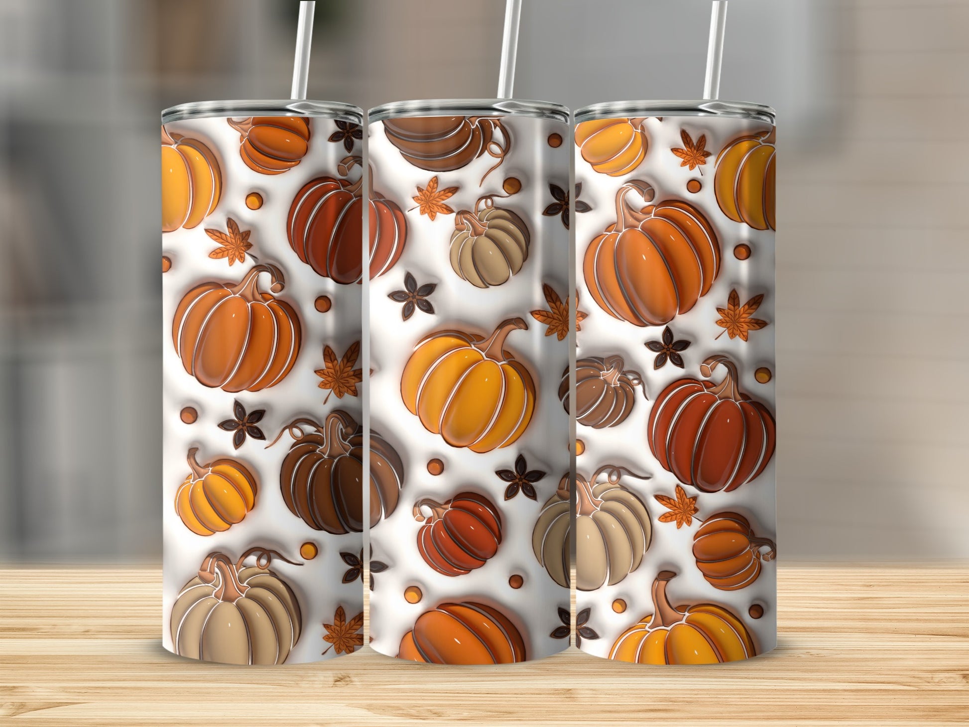 Three tumblers with a repeating pattern of pumpkins and leaves.