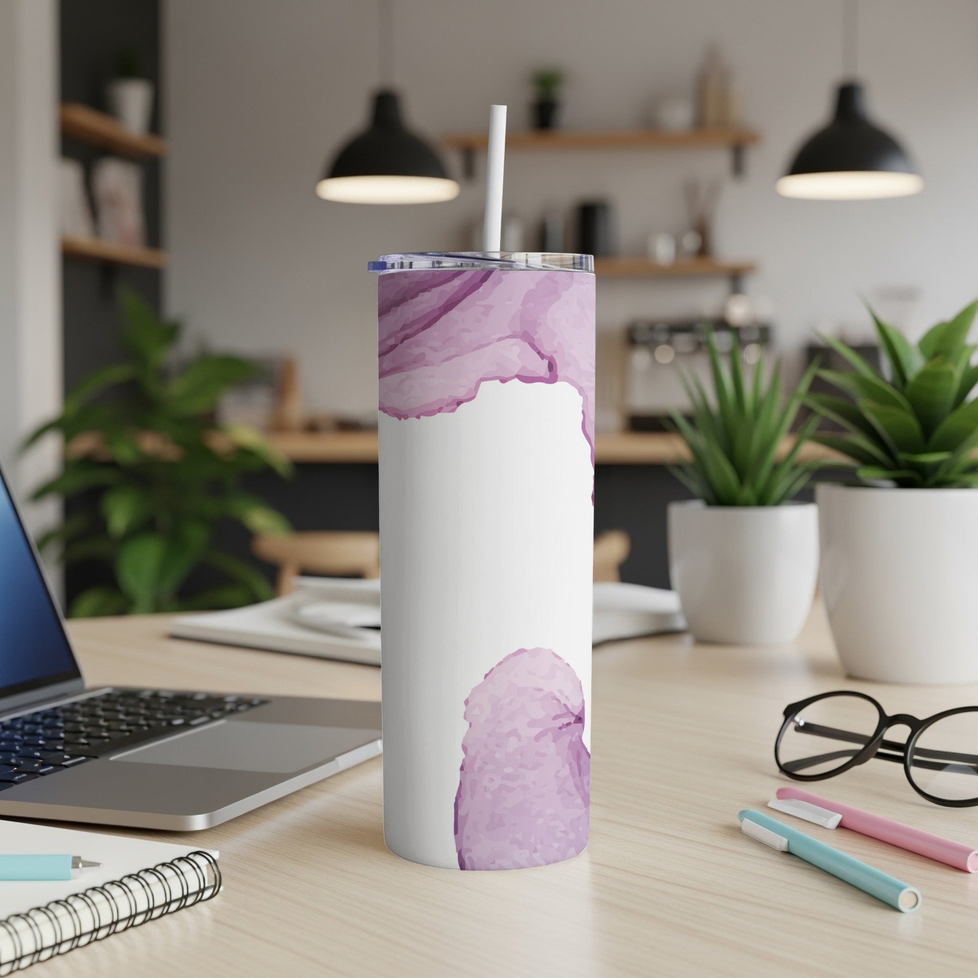 White tumbler with a purple watercolor splash design, on a desk.