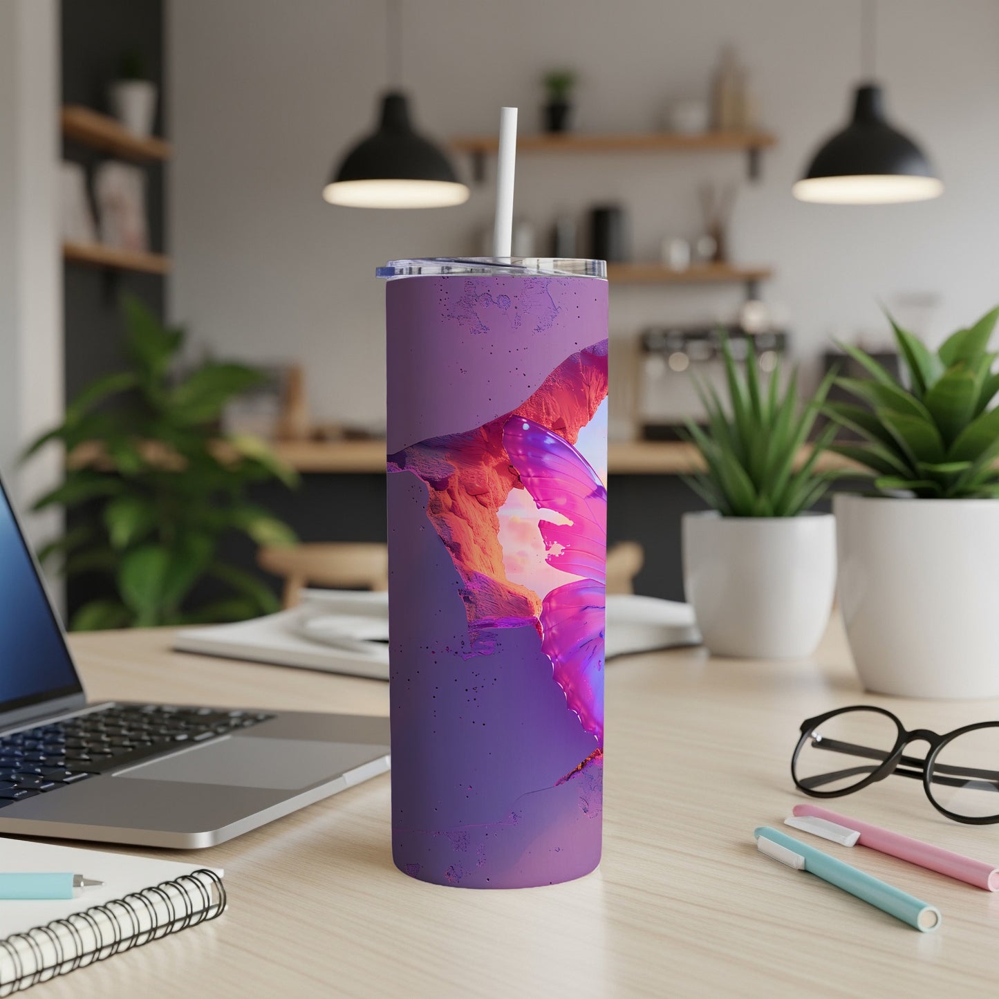 Purple tumbler with abstract pink and orange butterfly design on a desk.