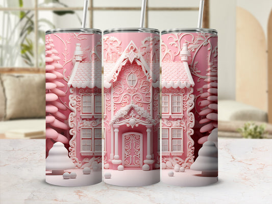Pink gingerbread house tumbler with white frosting, surrounded by snowy trees.