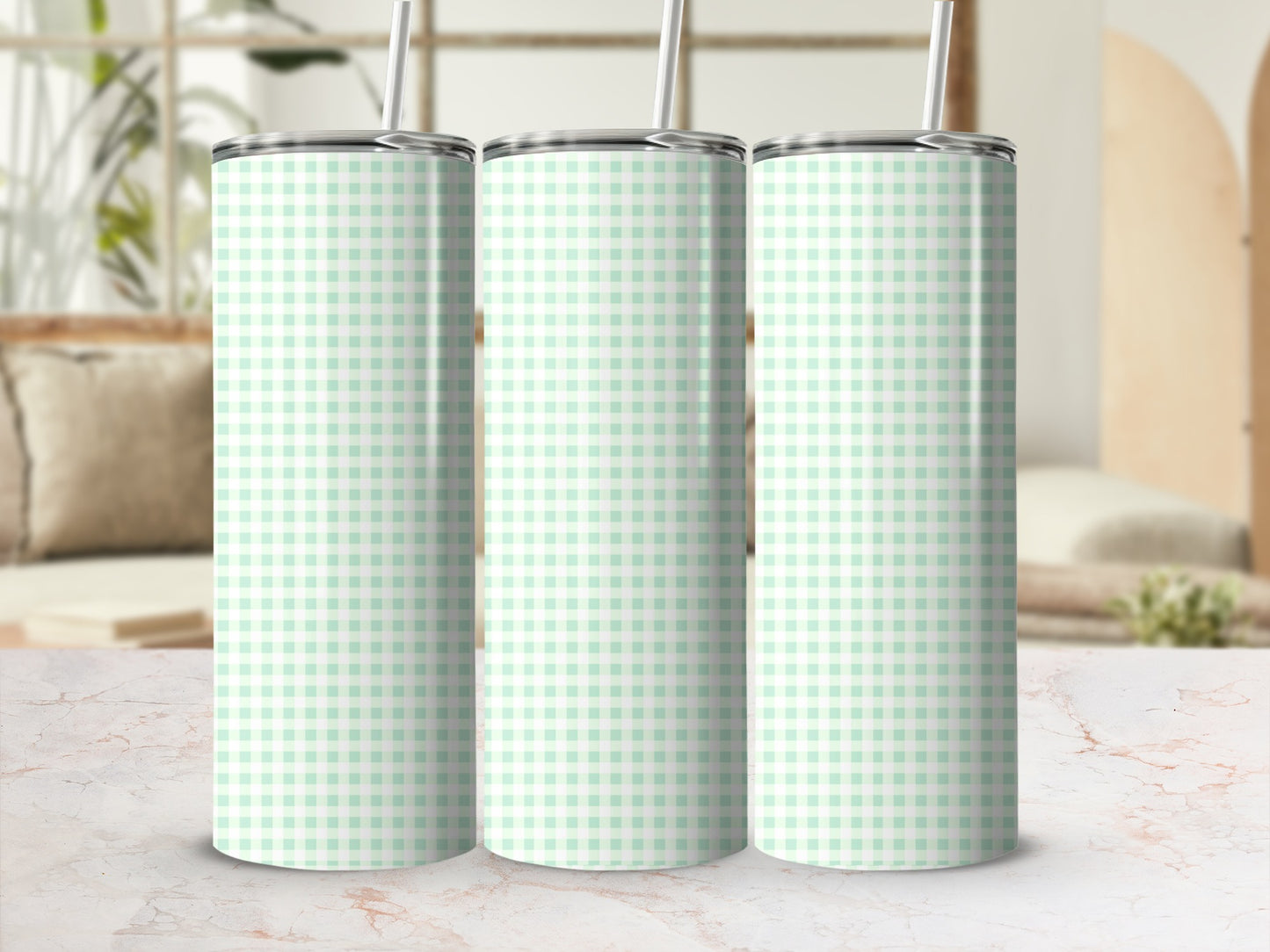 Three mint green and white gingham patterned tumblers with straws.
