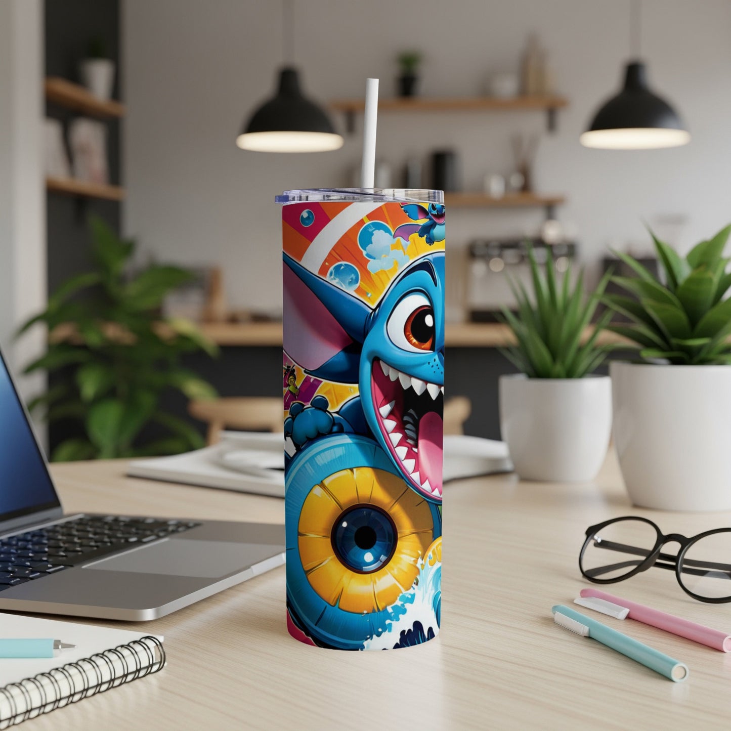 Tumbler with blue cartoon monster and colorful abstract design.