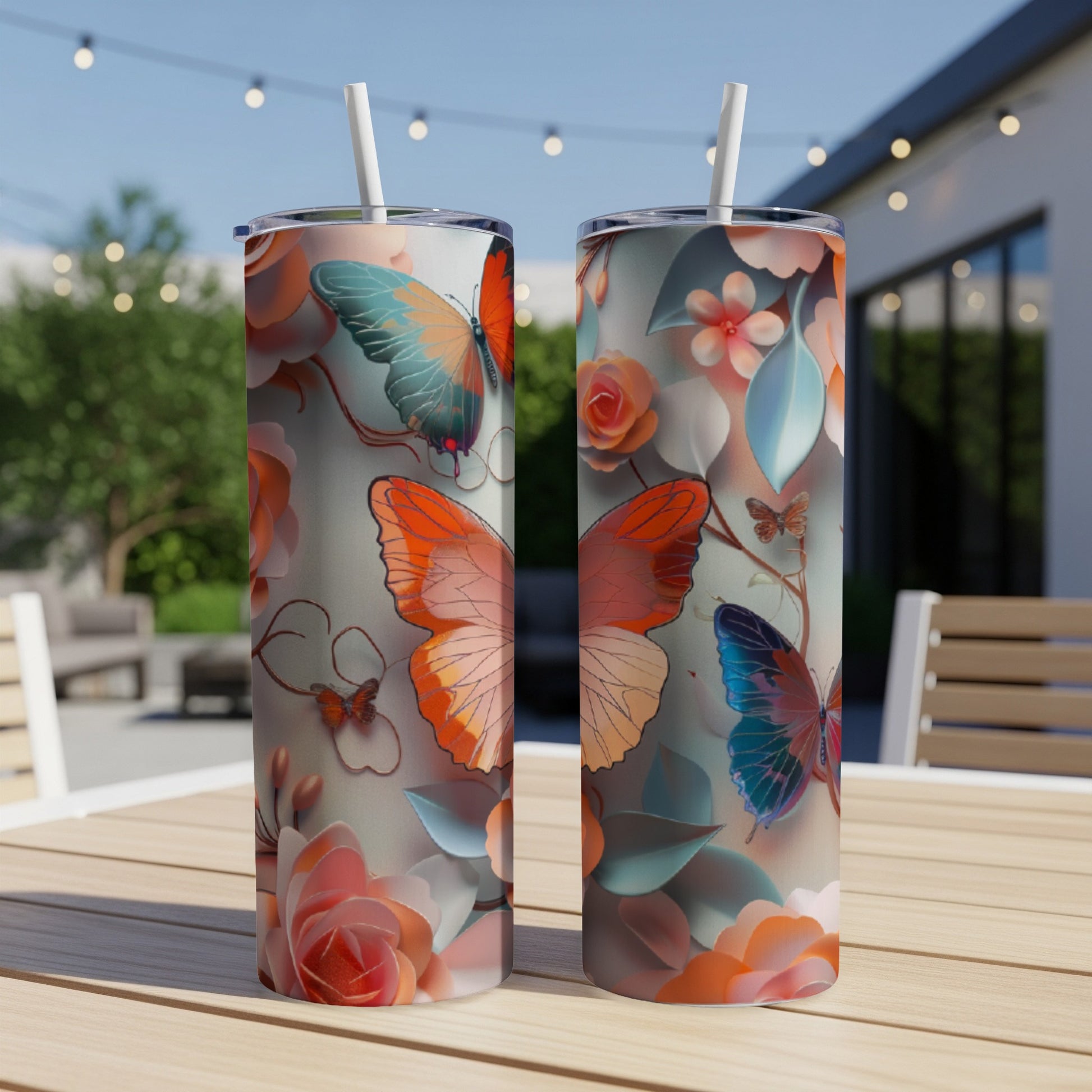 Two patterned tumblers with butterflies and floral designs sit on a table.