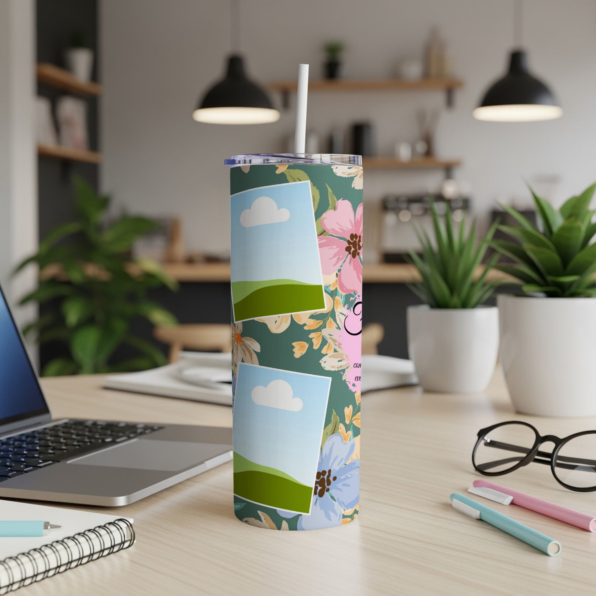 Floral tumbler with photo frames and a pink "G" monogram on a desk.