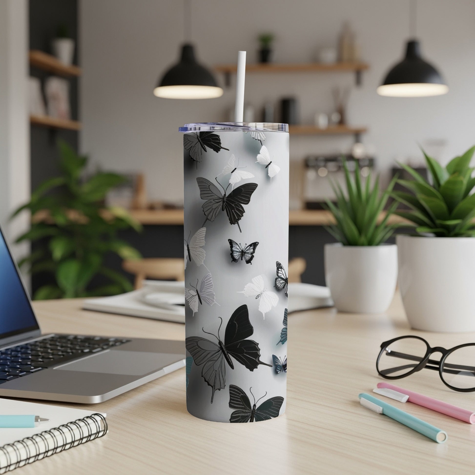 White tumbler with black and gray butterflies scattered across it.