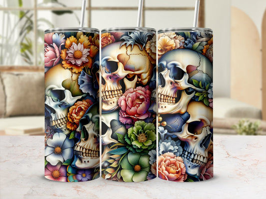 Three tumblers with floral skull designs in a blurred interior setting.