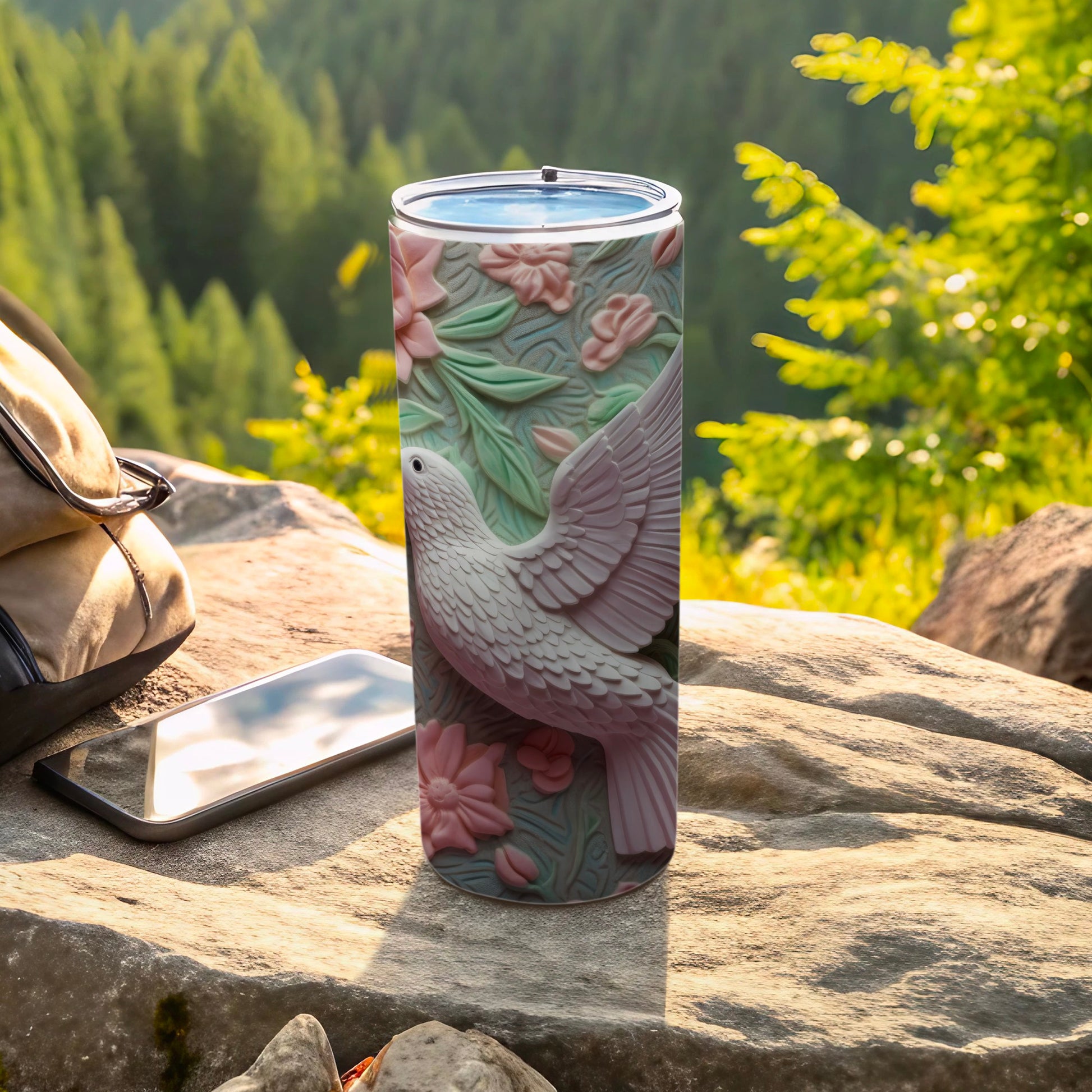 White dove with pink flowers on a textured tumbler, outdoors.