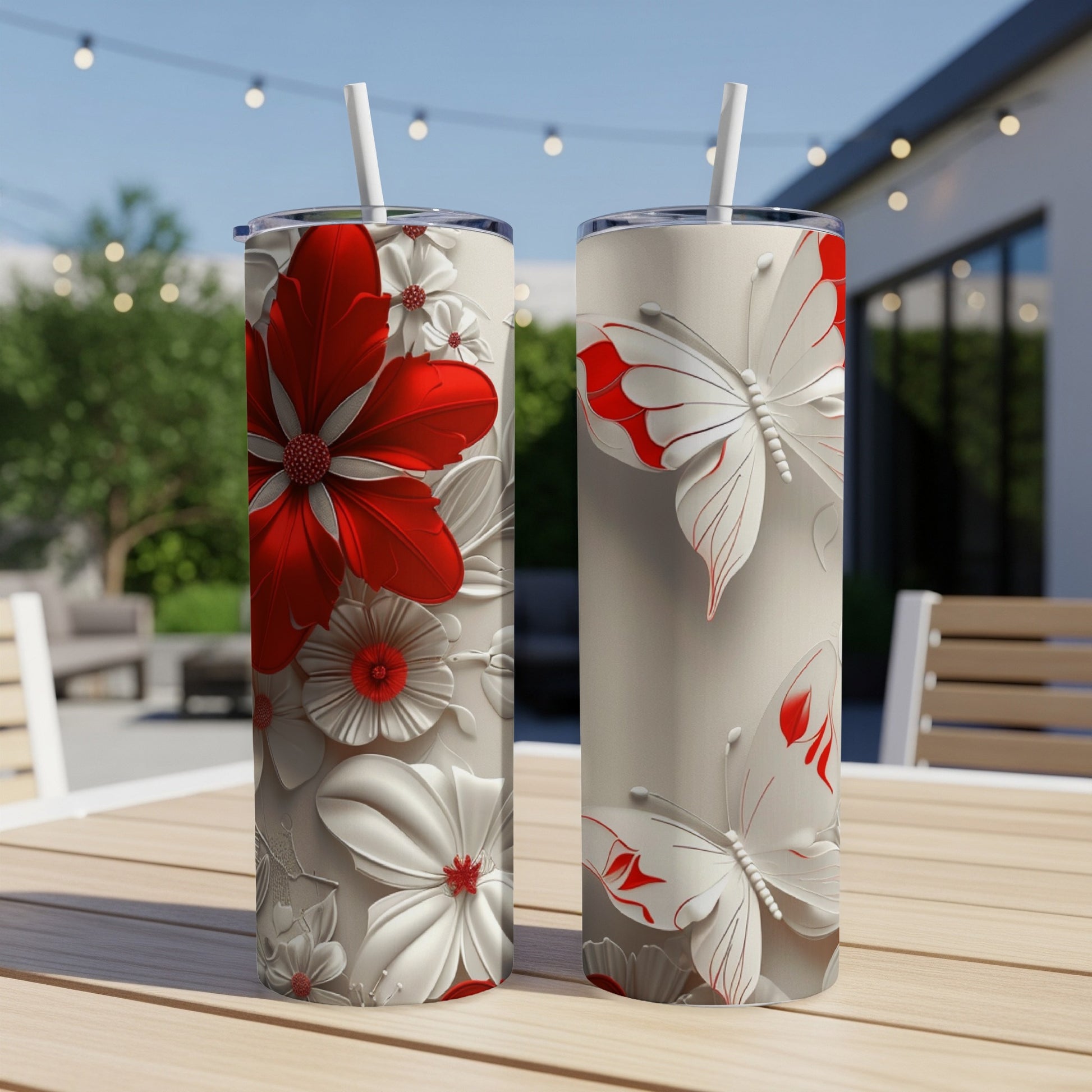 Two tall, narrow tumblers with red and white floral and butterfly designs.