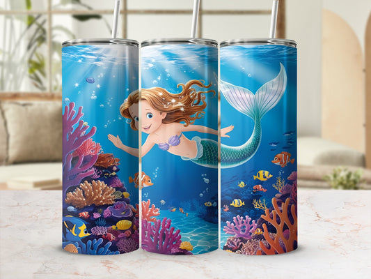 Smiling mermaid swims among colorful coral and fish underwater.
