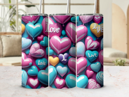 Three heart-patterned tumblers with straw, set against a blurred background.