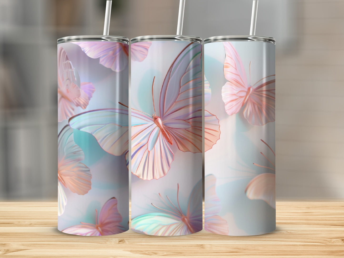 Three tumblers with iridescent butterfly design on a wooden surface.