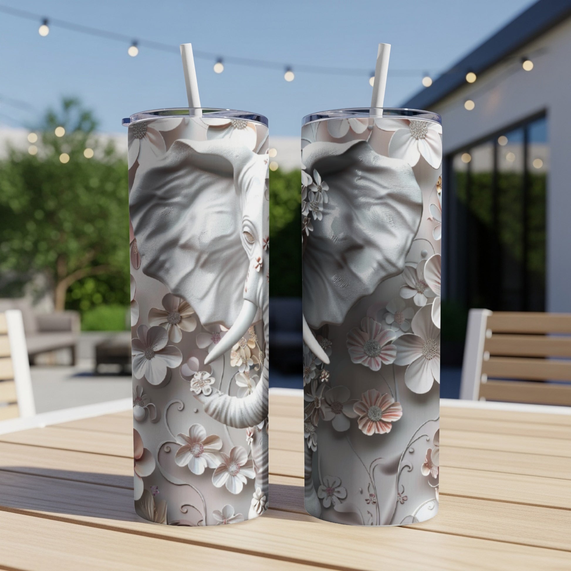 Two tumblers with floral elephant design on outdoor table.