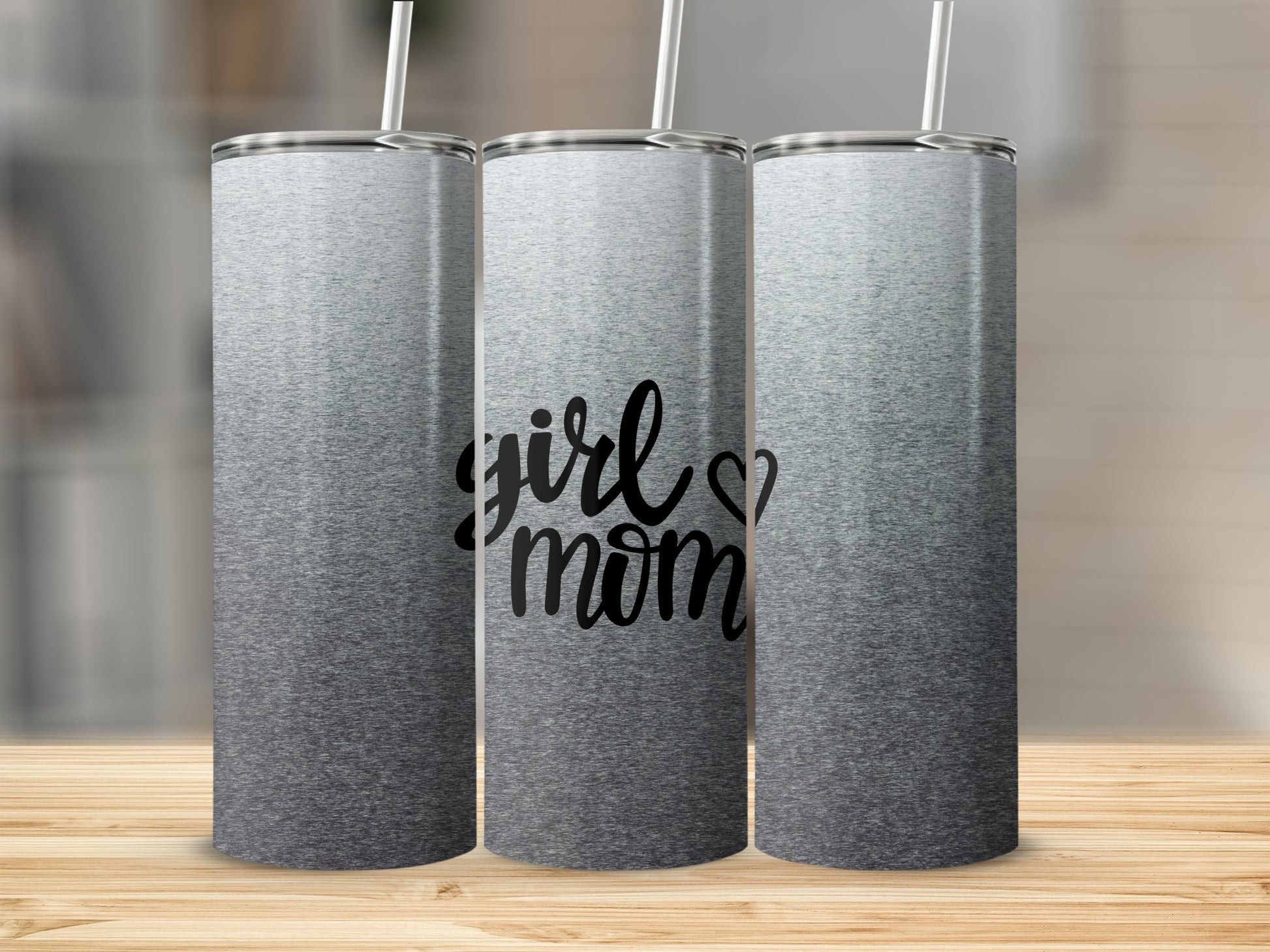 Gray ombre tumbler with "girl mom" text, displayed on a wooden surface.