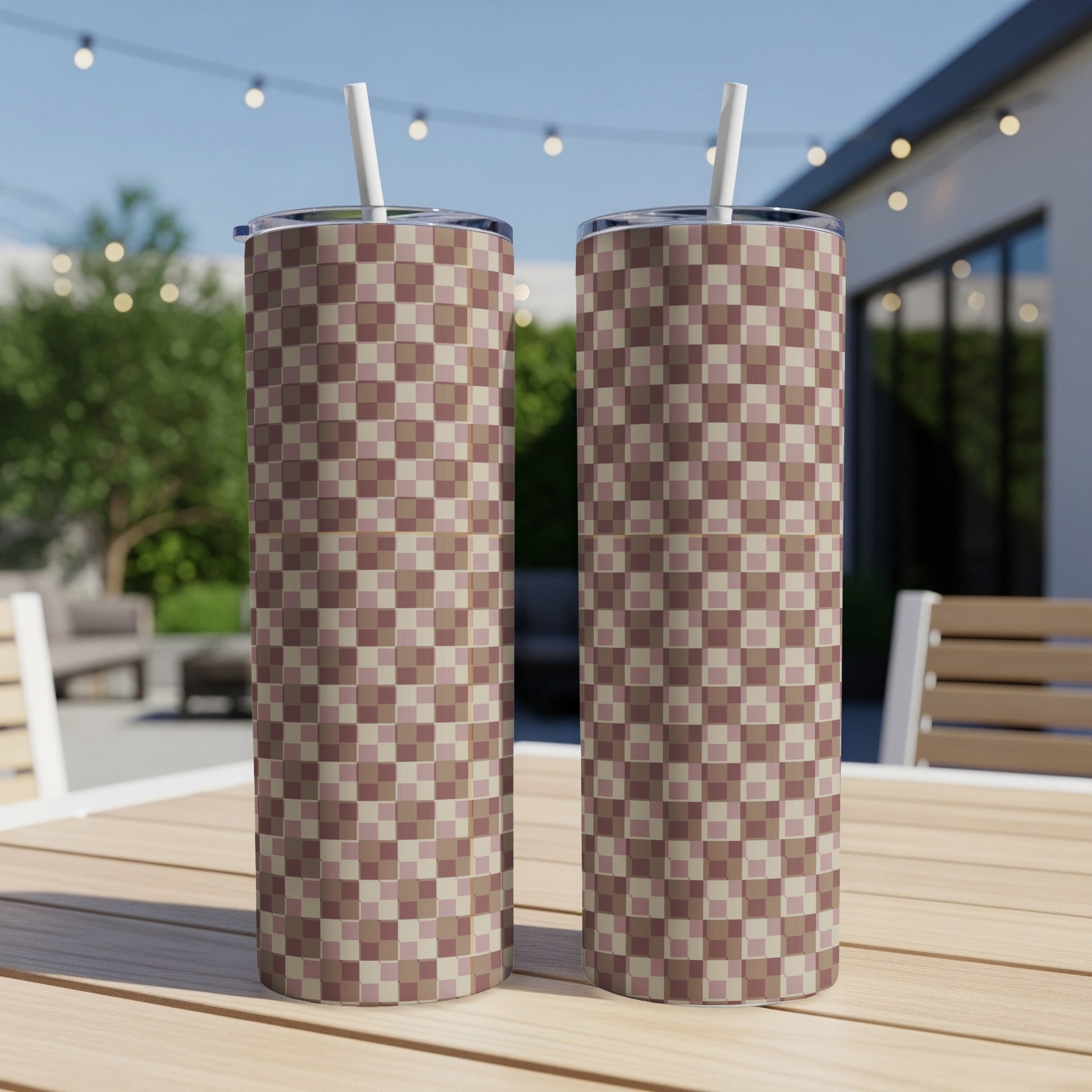 Two tall tumblers with a checkerboard pattern on a wooden table.
