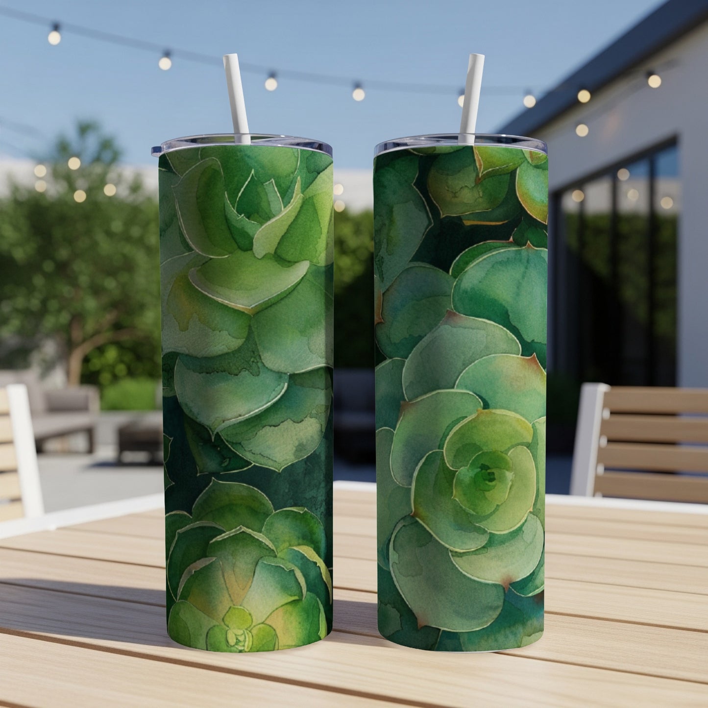 Two tall tumblers featuring a watercolor succulent design sit on a wooden table.