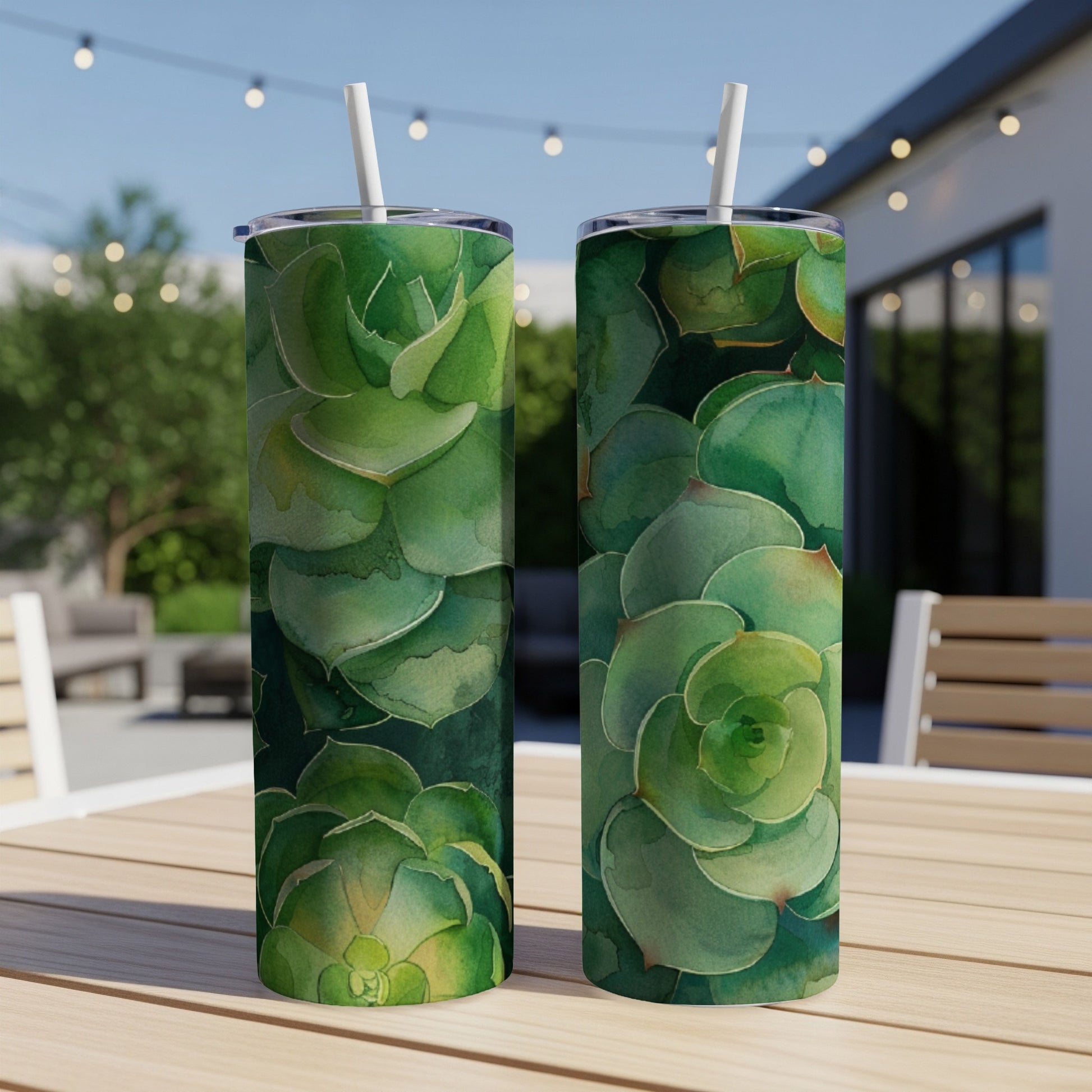 Two tall tumblers featuring a watercolor succulent design sit on a wooden table.