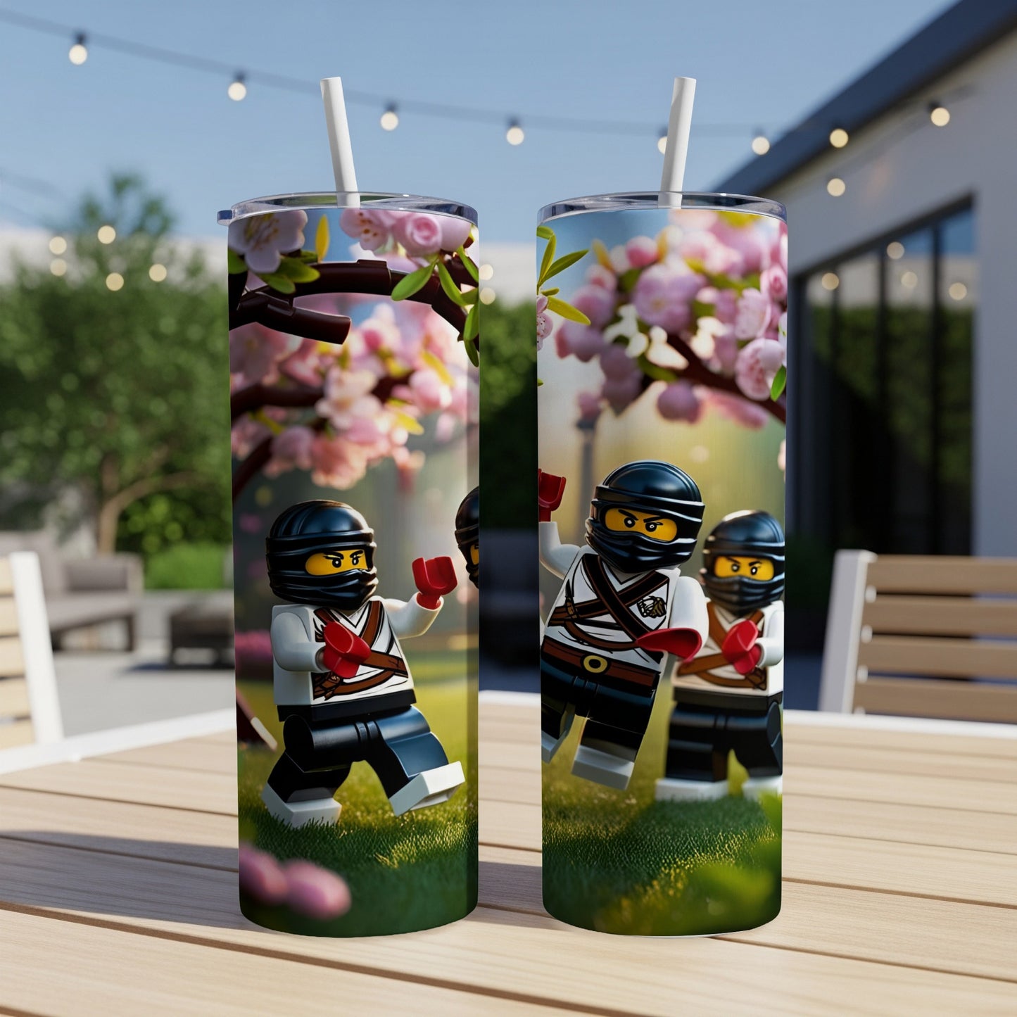Two Lego ninjas on a skinny tumbler with cherry blossoms.