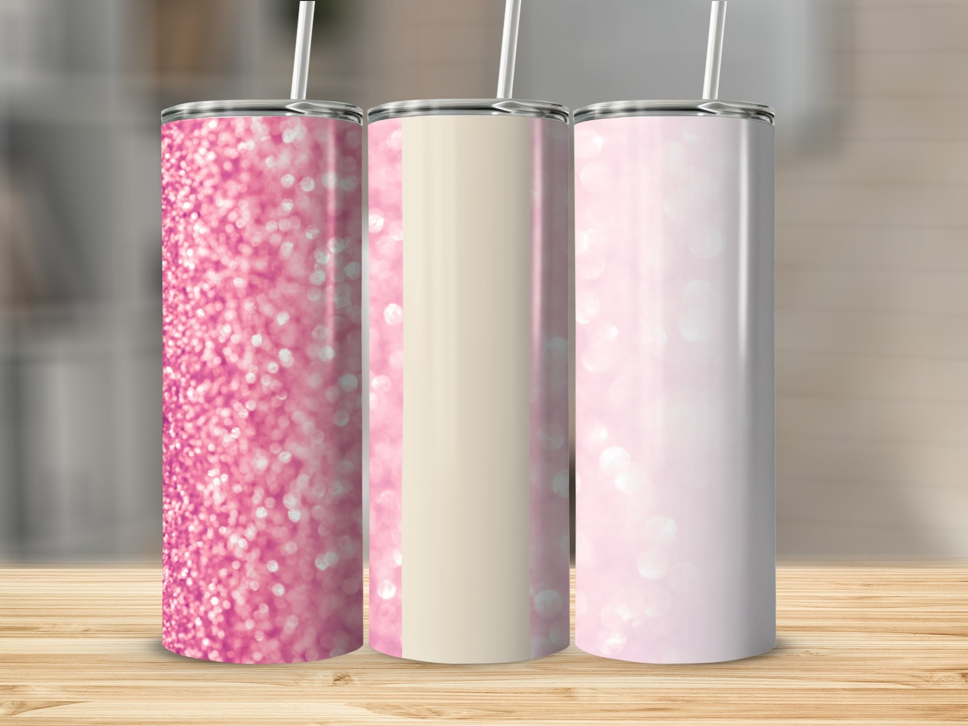Three glittery pink tumblers with straws on a wooden surface.