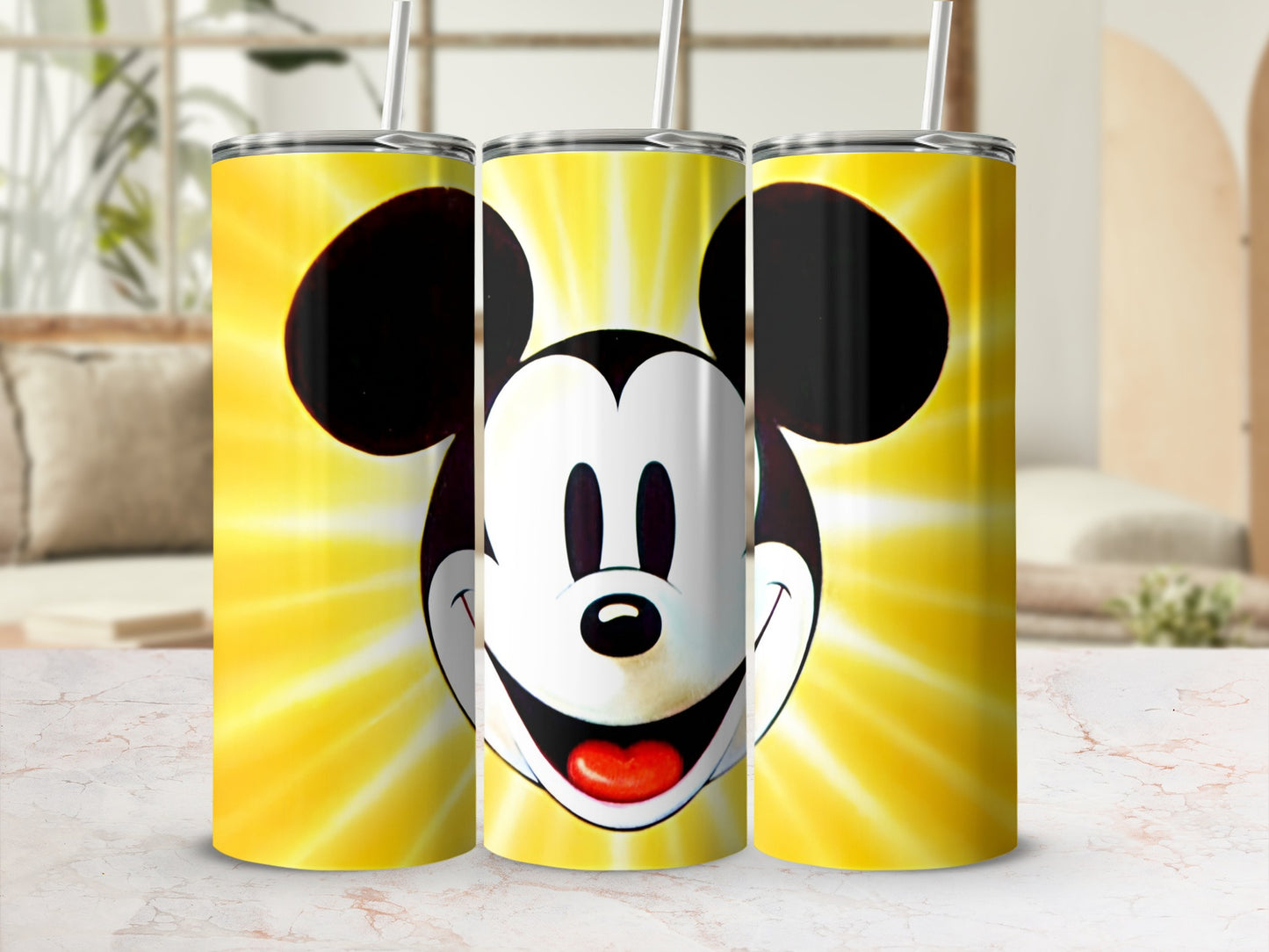 Mickey Mouse face on three yellow gradient tumblers with straws.