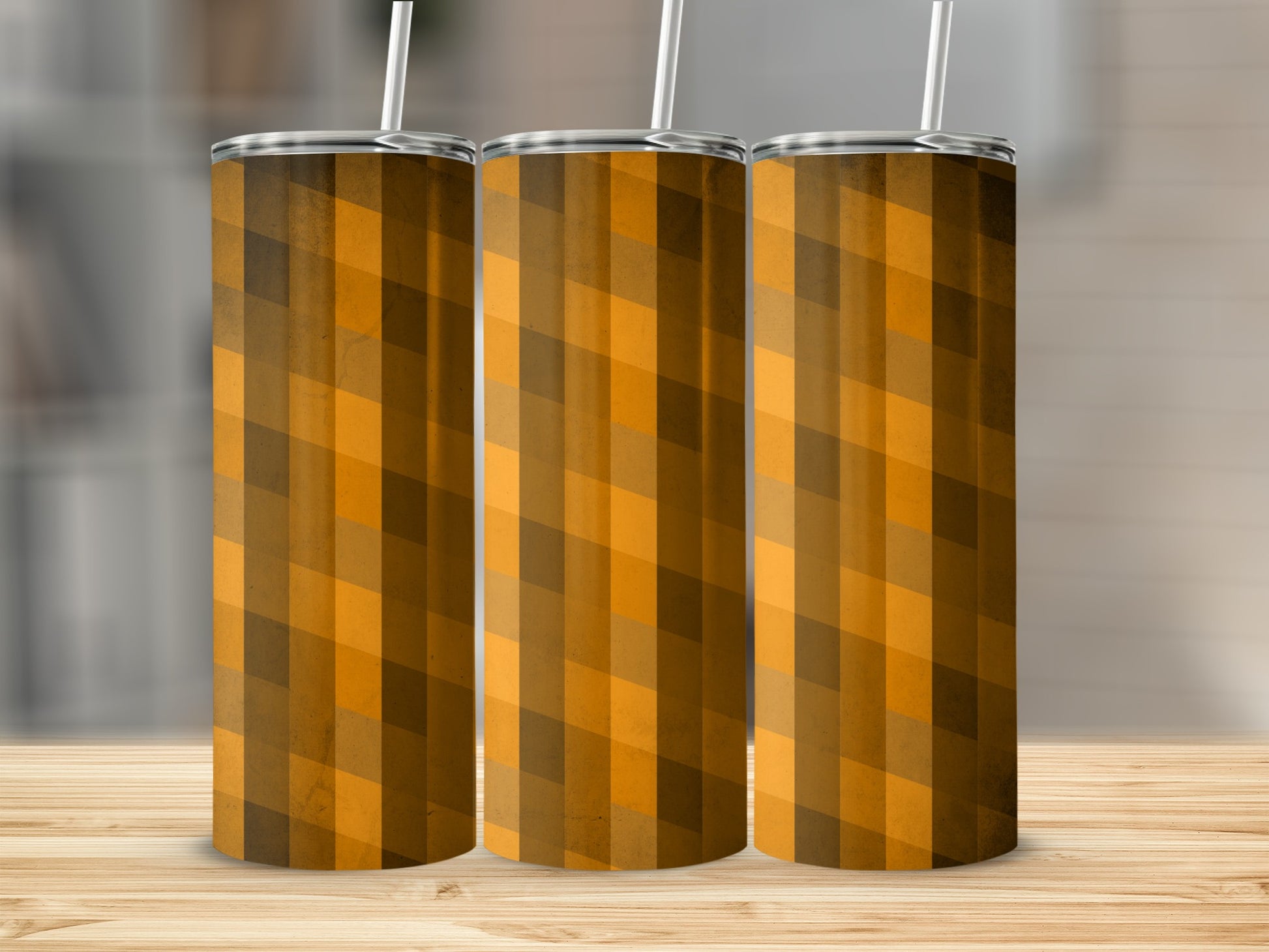 Three tumblers with a brown and orange plaid pattern on a wooden surface.
