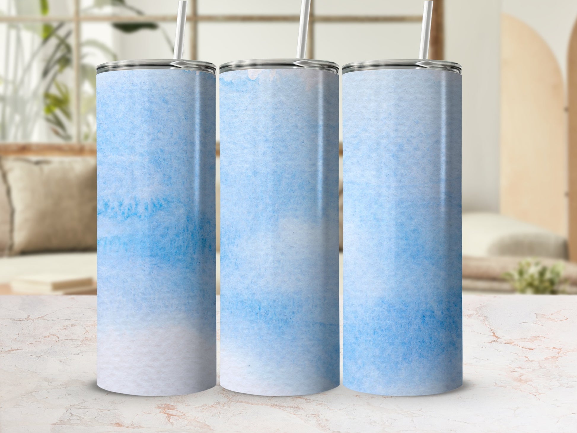 Three blue and white watercolor tumblers with straws.