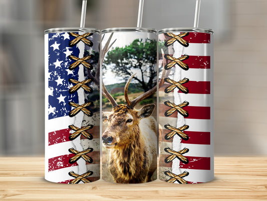 USA flag tumblers flanking a stag with antlers, crisscrossed by brown straps.