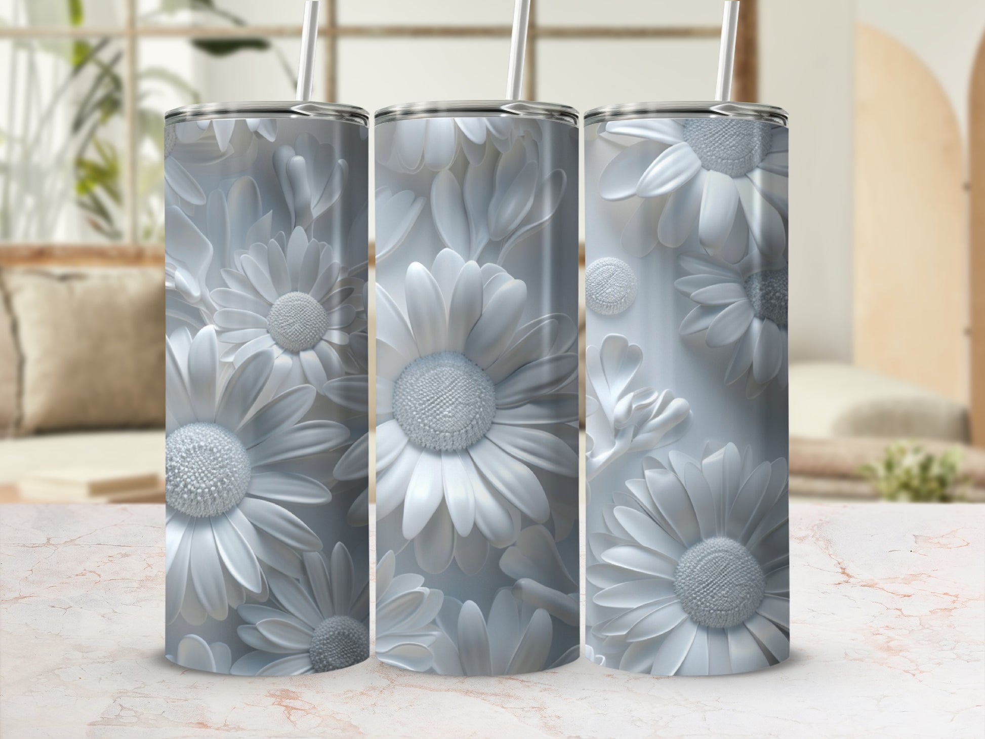 Three white embossed floral tumblers with straws on a marble surface.