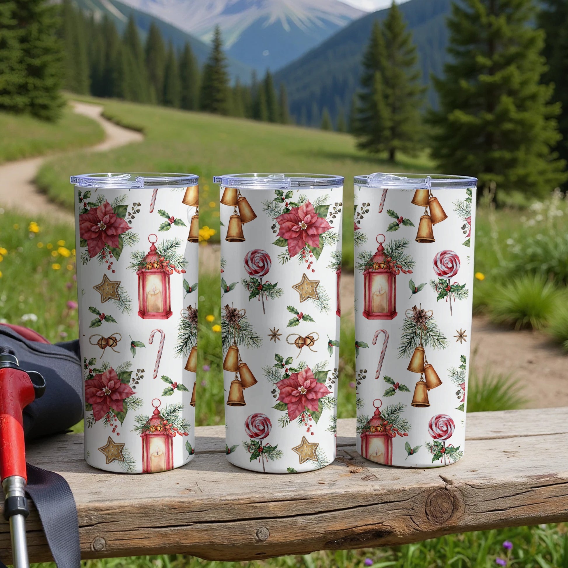 Three tumblers with a festive Christmas pattern, set outdoors.