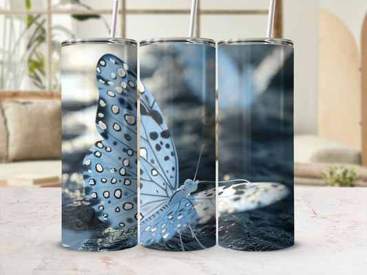 Three tumblers with blue butterflies and polka dots, with straws inserted.